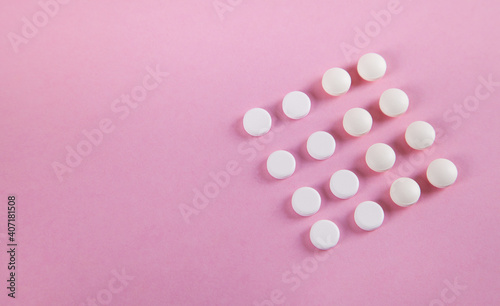 Pills are isolated on pink background.