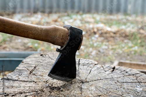 Ax on a stump. A large ax on a wooden deck. Preparation for felling wood or cutting meat.