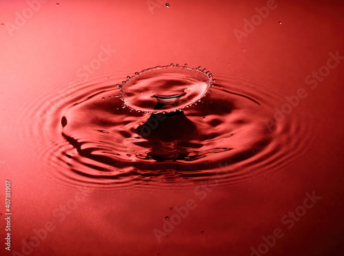 Macro Water drop double impact with spread crown in red.