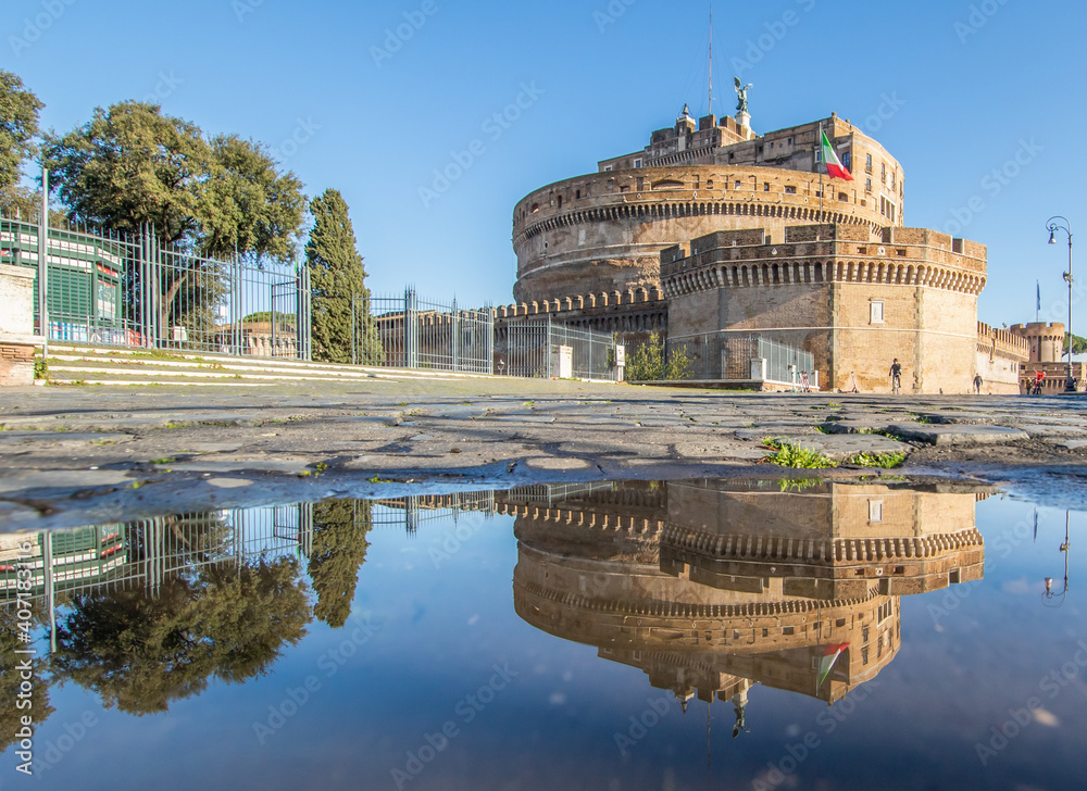 Fototapeta premium Rome, Italy - in Winter time, frequent rain showers create pools in which the wonderful Old Town of Rome reflect like in a mirror. Here in particular Castel Sant'Angelo