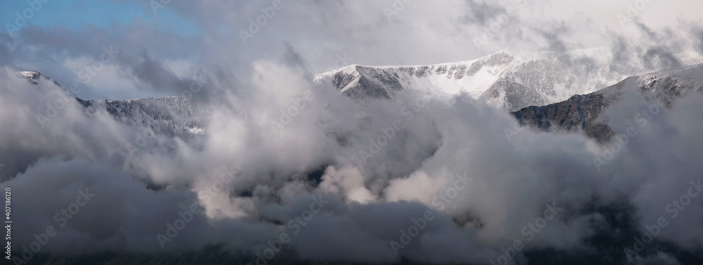 Mountains in the clouds, natural light. Panoramic view.