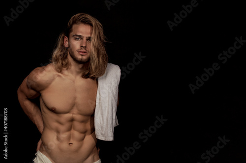 Sexy sport muscle strongface blond guy with long hair in white underwear on black isolated  font background