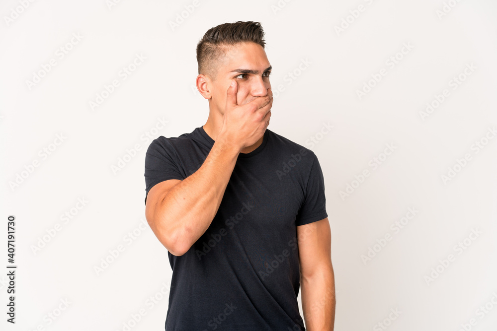 Young caucasian handsome man isolated thoughtful looking to a copy space covering mouth with hand. Young caucasian handsome man isolated thoughtful looking to a copy space covering mouth with hand.
