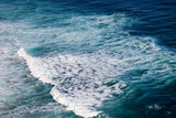 Oceanic deep blue waves with foam shot from above, power of nature background