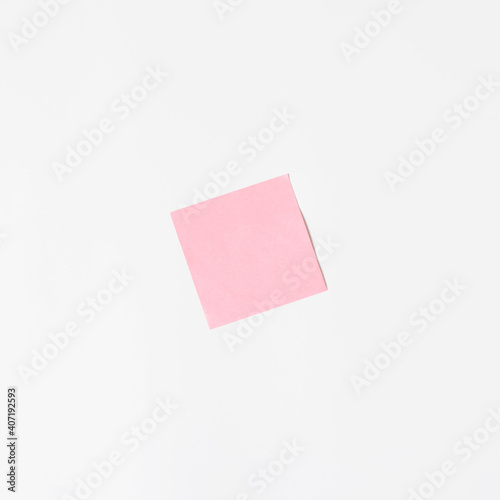 Pink sticker on a white wall, mock up. Blank sticky sheet, minimalism