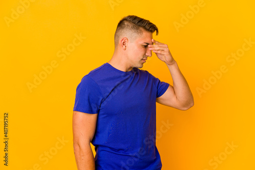 Young handsome caucasian man isolated having a head ache, touching front of the face.