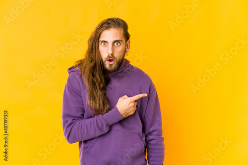 Young man with long hair look pointing to the side