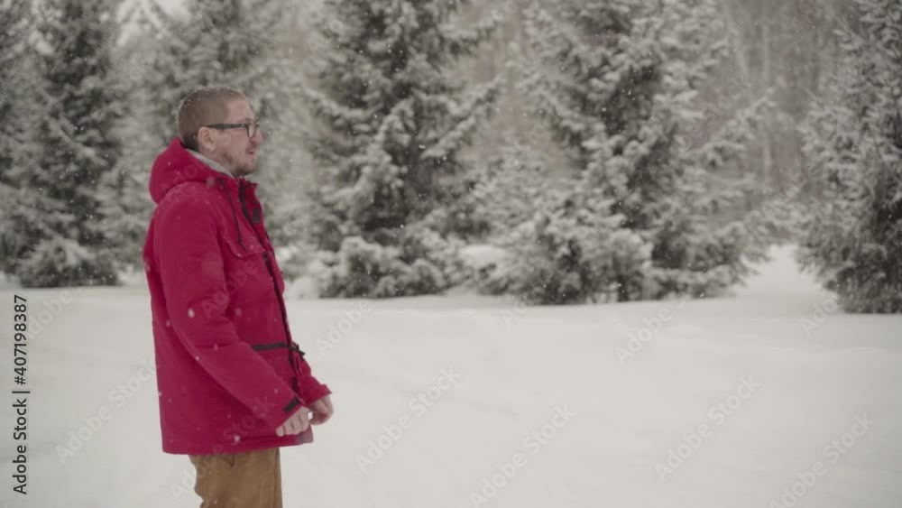 A man walks through a winter forest with snow covered trees on a beautiful frosty morning A man walks through a winter forest with snow covered trees on a beautiful frosty morning