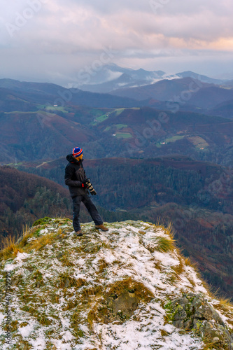 A photographer looking at the views of the snow-capped summit, on Mount Peñas de Aya in the town of Oiartzun near San Sebastián, Gipuzkoa. Basque Country