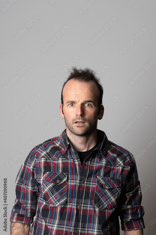 Mental health concept. Surprised mad looser man looking straight to the camera. Grey background with copy space Mental health concept. Surprised mad looser man looking straight to the camera. Grey background with copy space