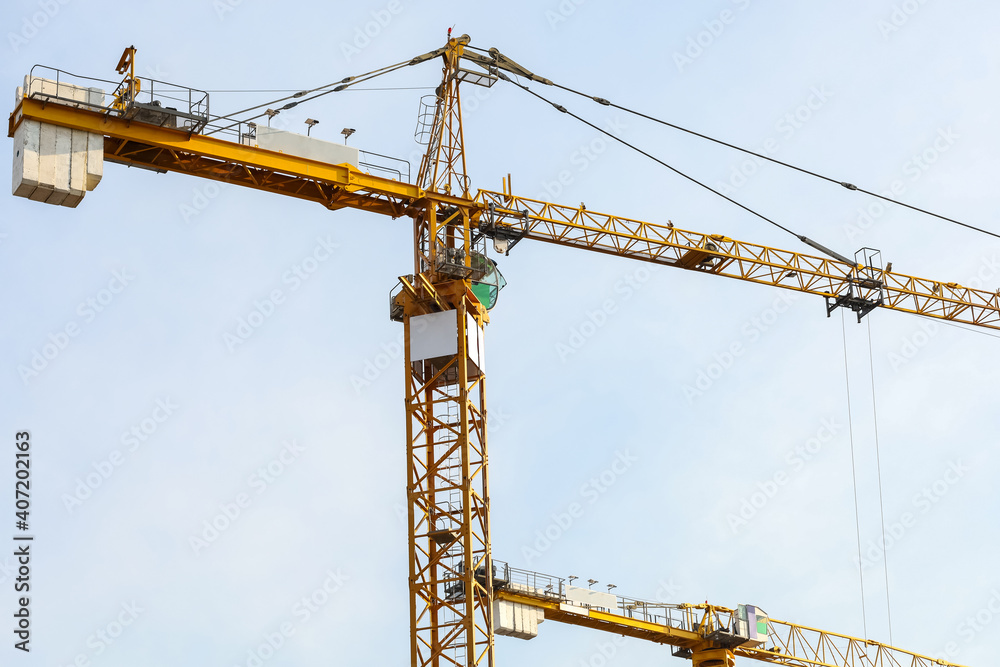 Industrial construction cranes and building. Working construction crane tower on the clear sky background