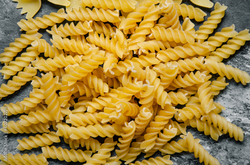 Auger pasta on gray and black background - close up Auger pasta on gray and black background - close up