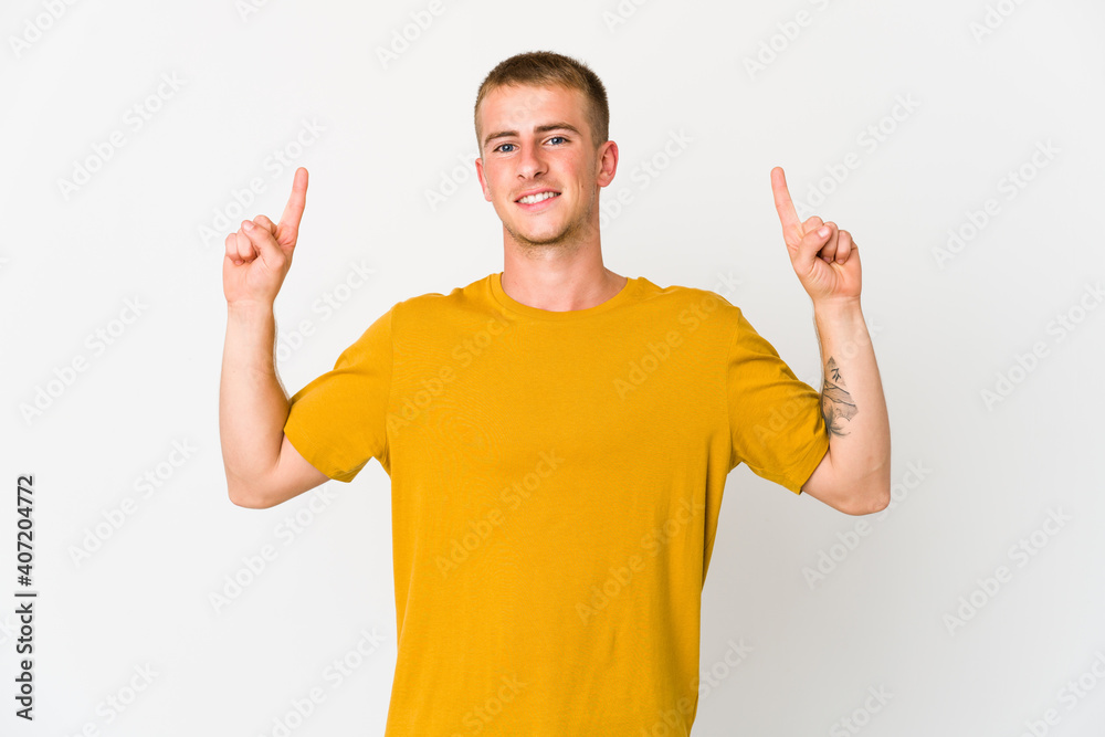 Young caucasian handsome man indicates with both fore fingers up showing a blank space. Young caucasian handsome man indicates with both fore fingers up showing a blank space.