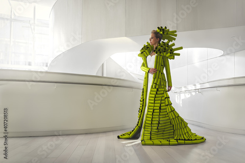 Photos Woman wearing a coat made of empty green toilet paper rolls, in a bright and min