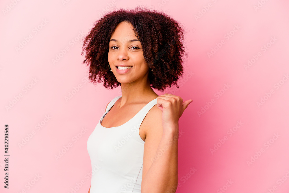 Young african american mixed race woman isolated points with thumb finger away, laughing and carefree. Young african american mixed race woman isolated points with thumb finger away, laughing and carefree.