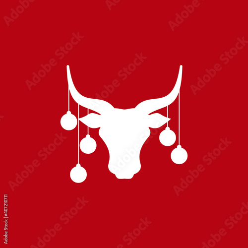 Bull head with red christmas tree toy balls on horns, snow and stars.