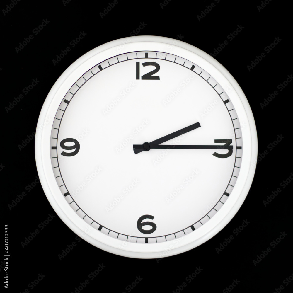 White round analog wall clock isolated on black background. White round analog wall clock isolated on black background.
