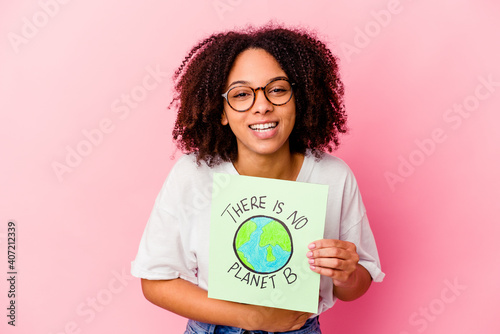Young african american mixed race woman holding a world protection concept cardboard laughing and having fun.