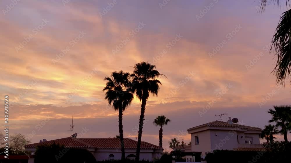 Beautiful sunrise early morning cloudy sky above houses and palm trees. High quality 4k footage Beautiful sunrise early morning cloudy sky above houses and palm trees. High quality 4k footage