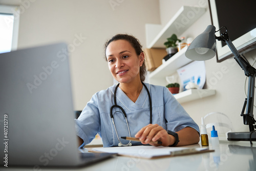 Doctor clicking on a laptop before her