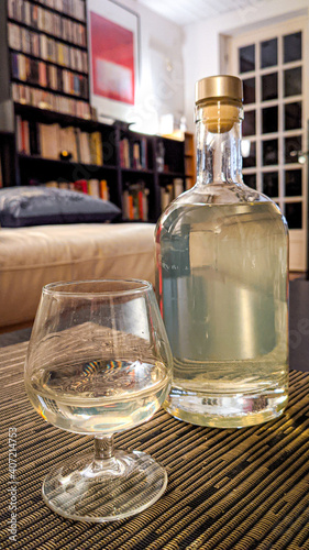 Une bouteille et un verre de génépi sur table
