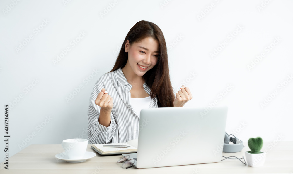 Video call, a young Asian woman communicates via online video long distance, looking at the digital laptop screen, happily greeted with a friend Video call, a young Asian woman communicates via online video long distance, looking at the digital laptop screen, happily greeted with a friend