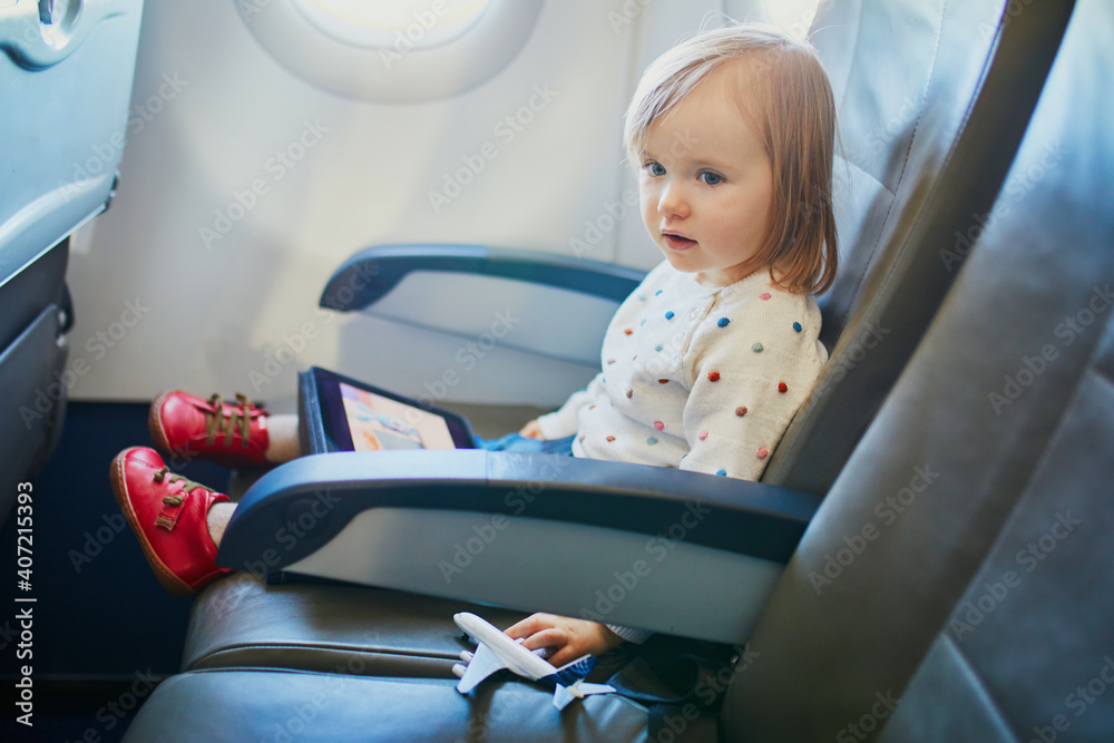 Adorable little toddler girl traveling by plane Adorable little toddler girl traveling by plane