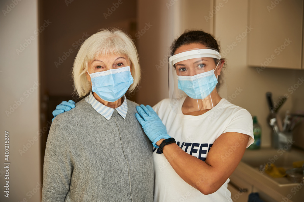 Two women in medical masks looking ahead