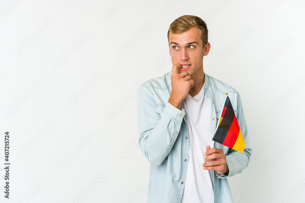 Young caucasian man holding a german flag isolated on white background Young caucasian man holding a german flag isolated on white background
