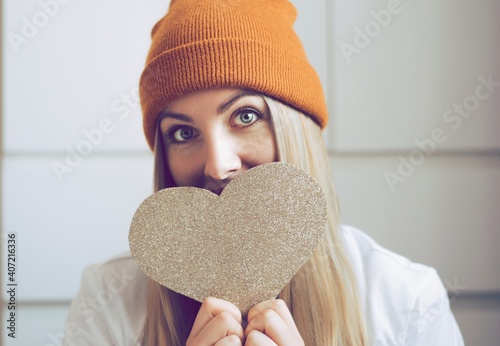 Pretty hipster girl with a big paper heart on the hands. Portrait of smailing girl ready for Snt. Valentines day. Cupid day. Love