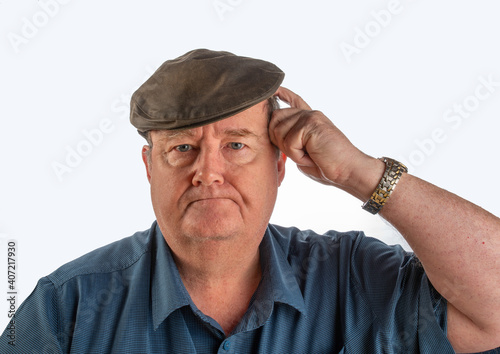 Man with flat cap scratching head