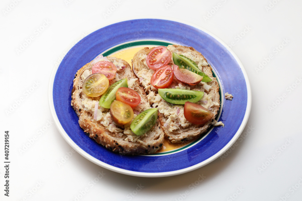 Baby tomatoes tuna mayonnaise mixed salad on toasted brown sandwich bread Baby tomatoes tuna mayonnaise mixed salad on toasted brown sandwich bread