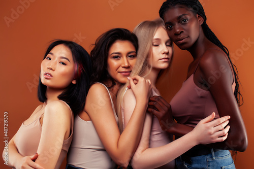 SaveDownload Previewyoung pretty asian, caucasian, afro woman posing cheerful together on brown background, lifestyle diverse nationality people concept