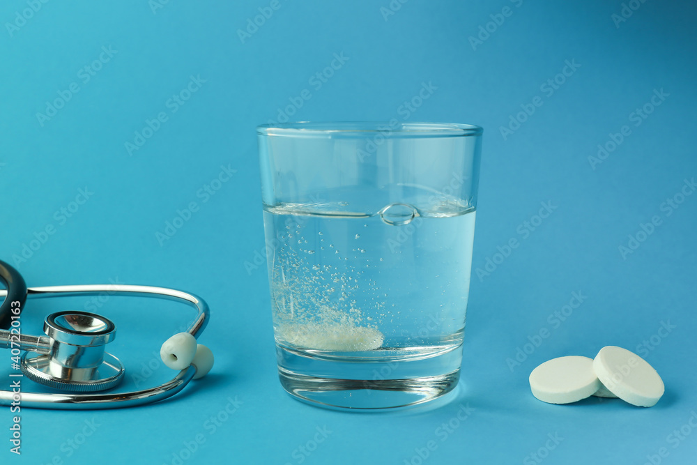 effervescent vitamin C tablet dissolves in water. a glass of water and