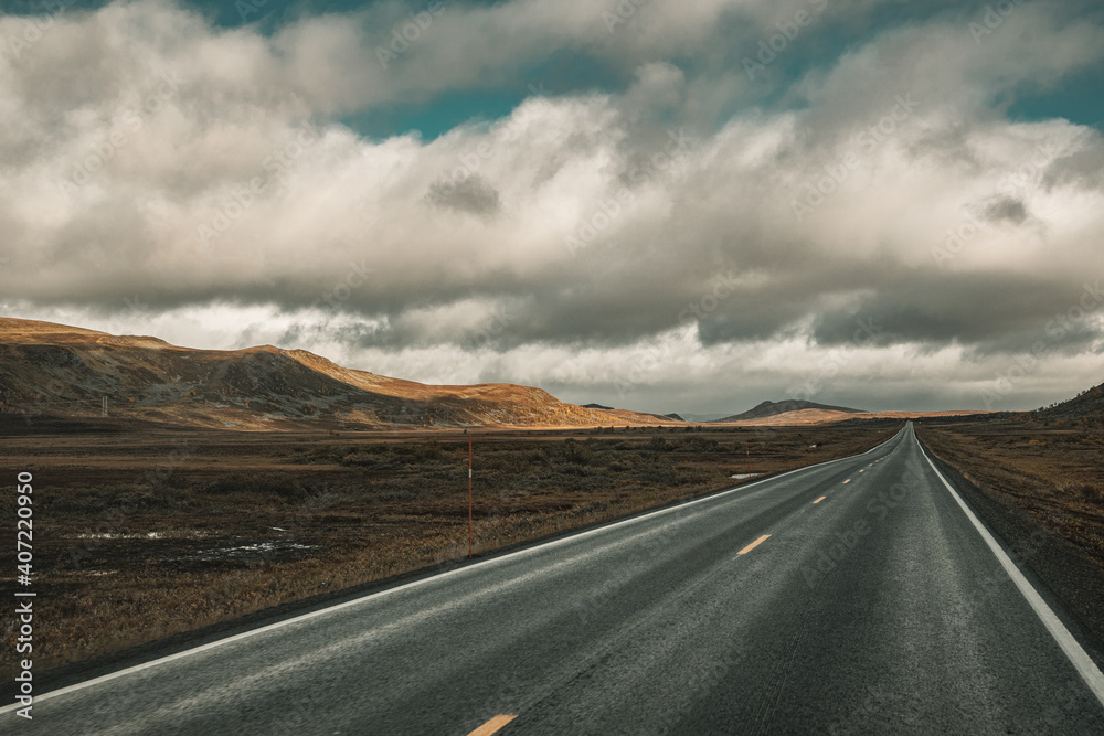 Straight road through a sparse landscape in Norway