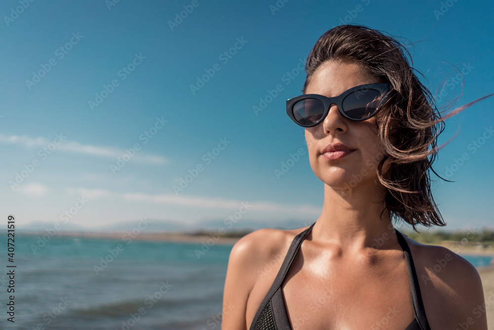 Beautiful young female in bikini on gorgeous sandy beach enjoying summertime vacation Beautiful young female in bikini on gorgeous sandy beach enjoying summertime vacation