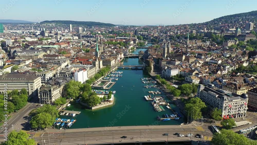 Aerial drone footage of the famous Zurich old town along the Limmat river and lake Zurich on a sunny summer day in Switzerland largest city. 