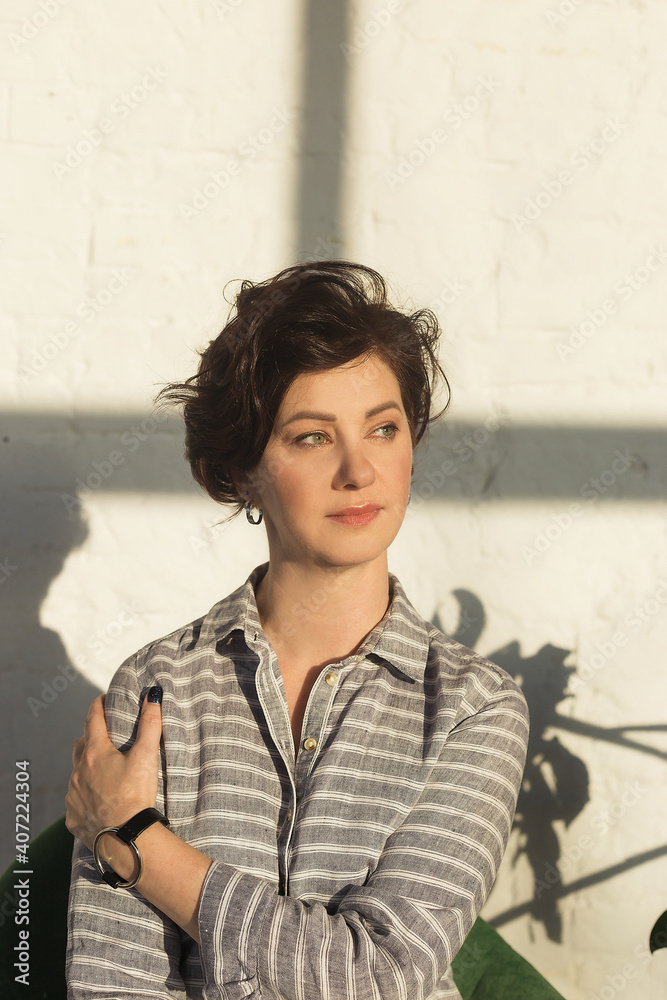 Portrait of a beautiful adult woman. In the solar studio. A pensive pose Portrait of a beautiful adult woman. In the solar studio. A pensive pose