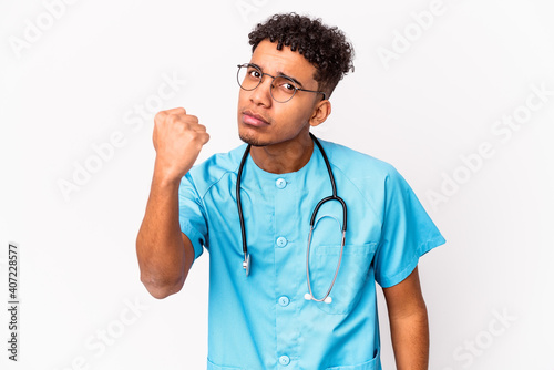 Young african american curly nurse man isolated showing fist to camera, aggressive facial expression.
