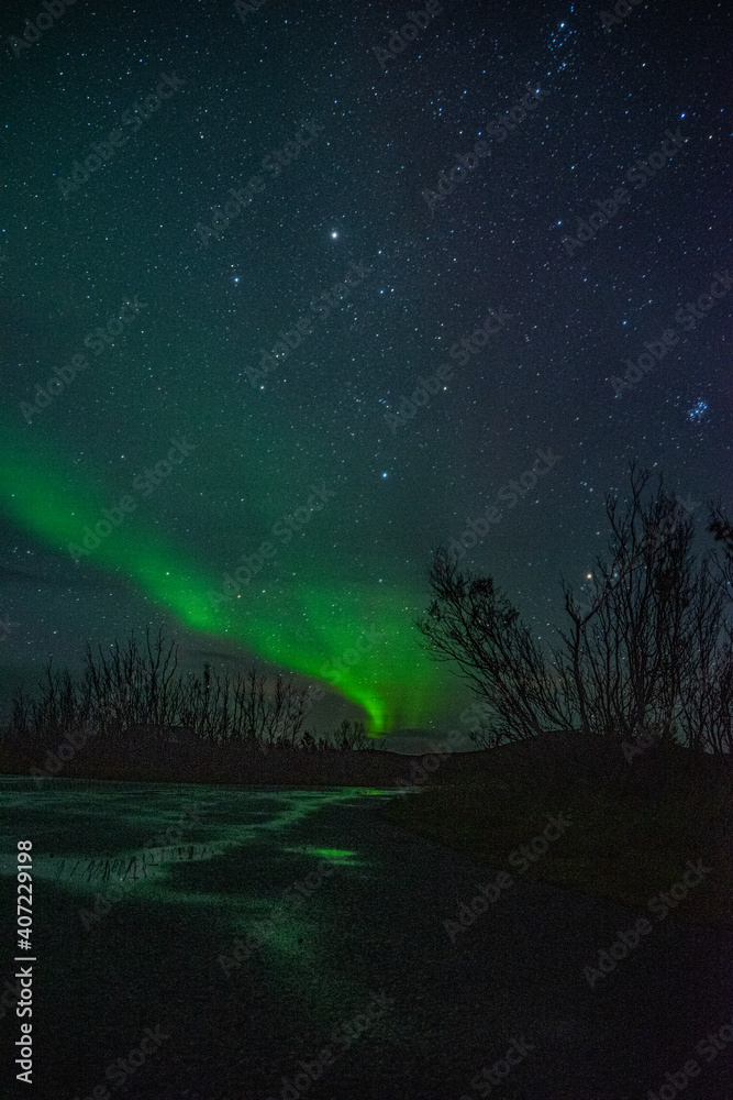 Strip of a northern light with clouds on the sky