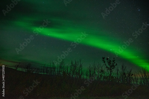 Strip of a northern light with clouds on the sky