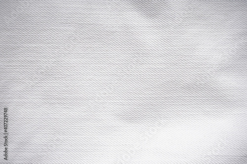 White denim jeans fabric background. Stylish vintage jeans, dirty washed gray clothes.