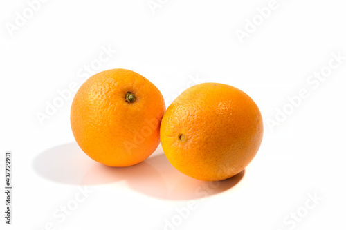 Two ripe oranges on a white isolated background, shadow.