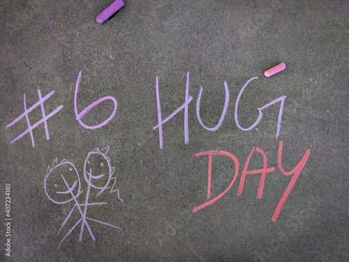 The inscription text on the grey board, #6 Hug day with hand drawn hugging couple . Using color chalk pieces. Valentines week