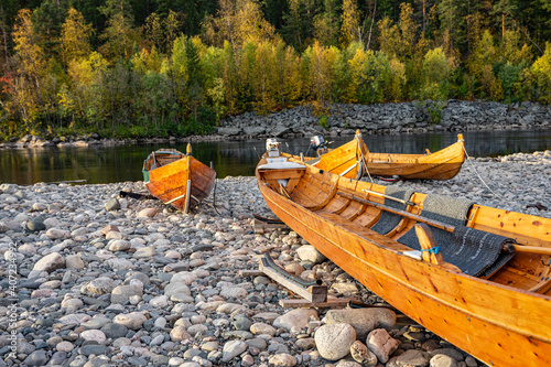 Wooden boats on stones on ariver in Norway photo