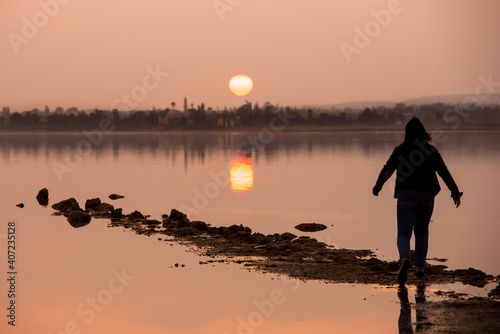 Unrecognised person standing and enjoying the sunset at a lake. Larnaca Cyprus © Michalis Palis
