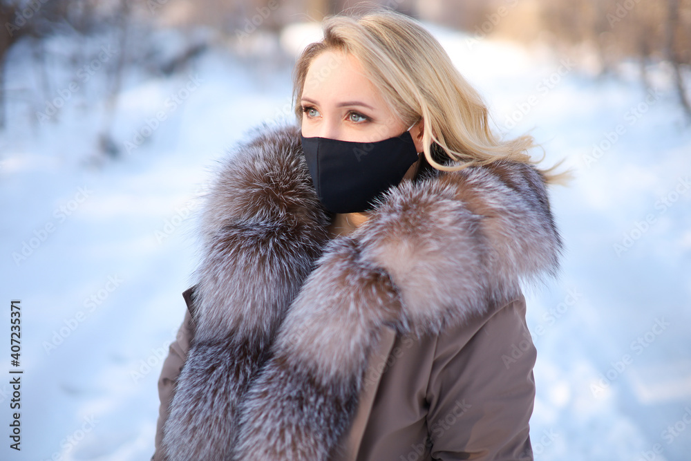 a blonde with a fur collar in a black protective mask a blonde with a fur collar in a black protective mask