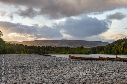 Wooden boats on stones on ariver in Norway photo