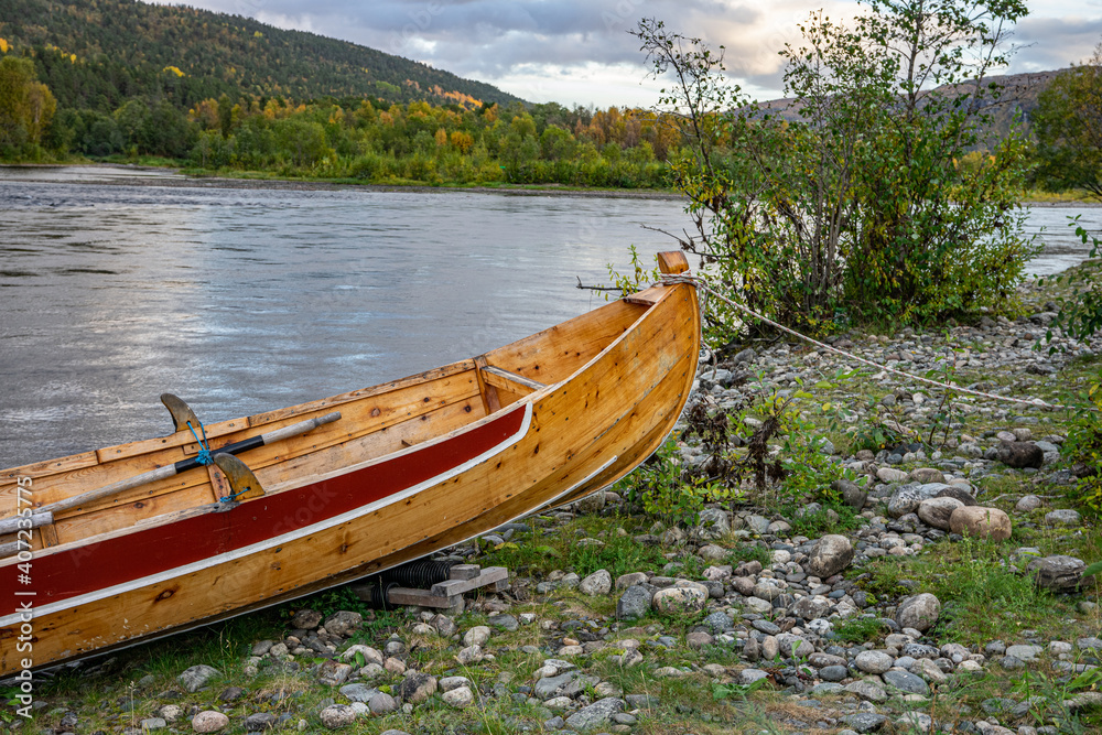Obraz premium Wooden boats on stones on ariver in Norway