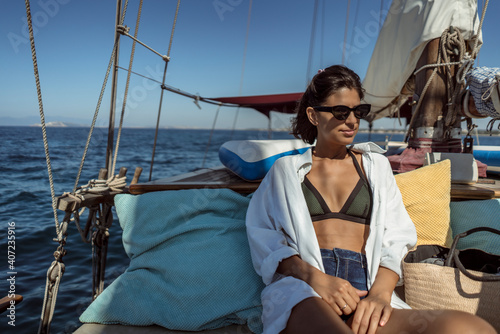 Beautiful happy young woman on sea vacation on a boat tour. Gorgeous female enjoying summer time holiday on sailing boat.